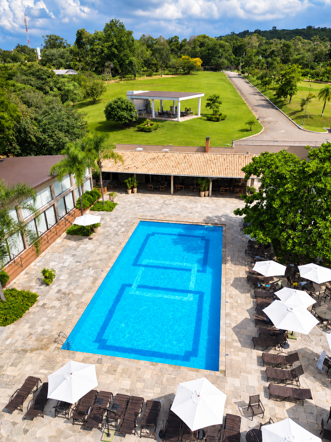 Uma grande piscina cercada por palmeiras e cadeiras