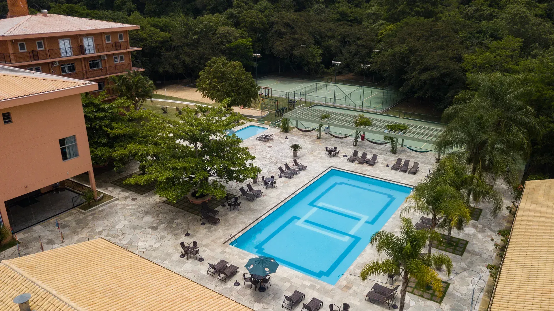 Uma grande piscina cercada por palmeiras e cadeiras