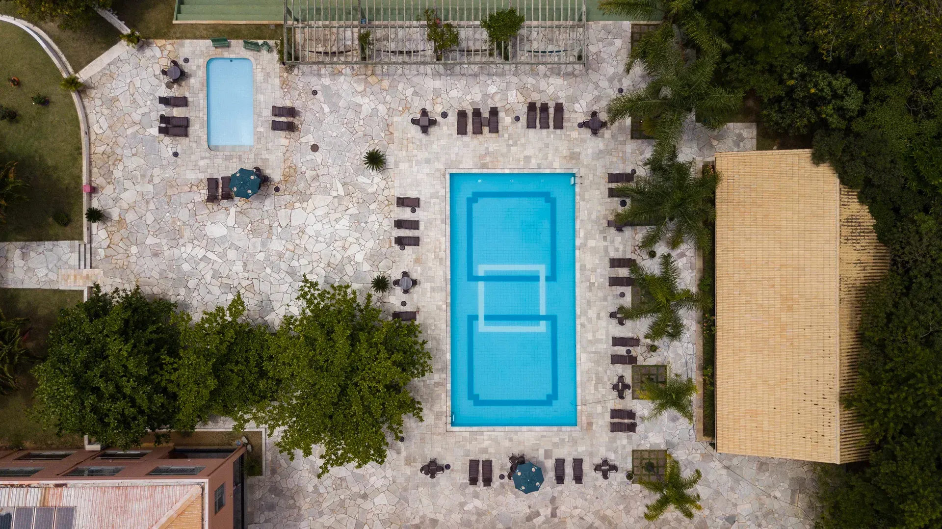 uma vista aérea de uma piscina e quadra de tênis