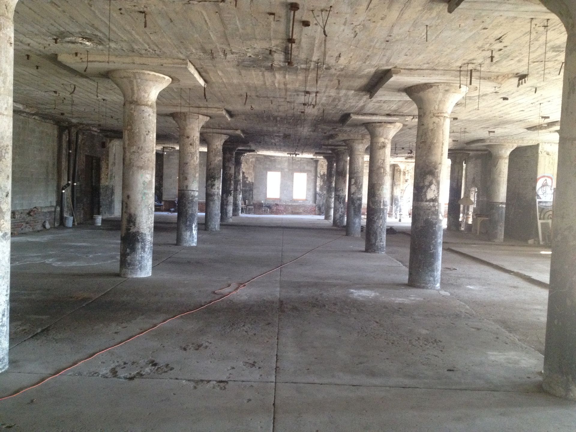 Open unfinished interior with exposed concrete columns, ceiling and floor