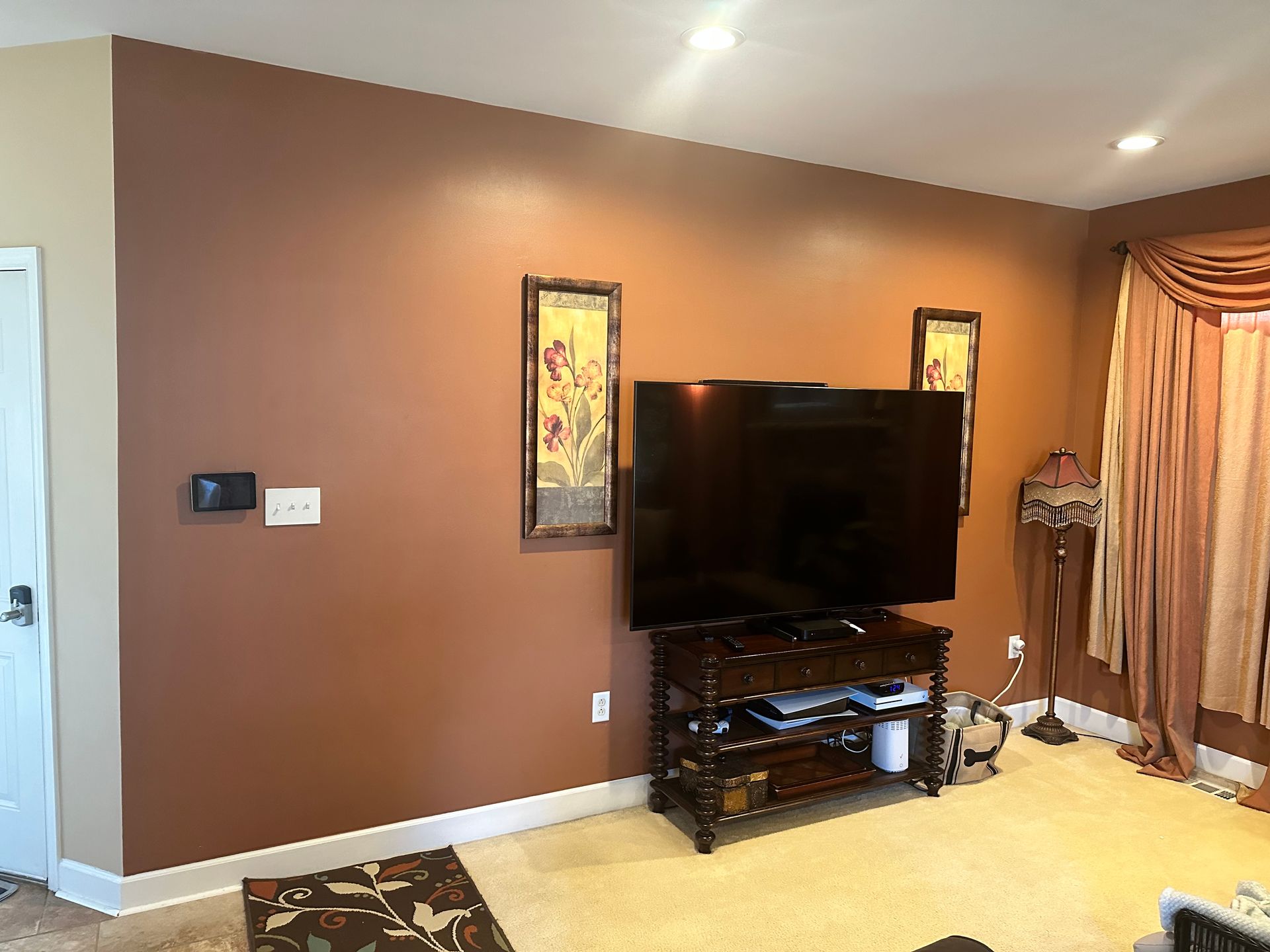 Before: brown living-room wall with a television on a stand