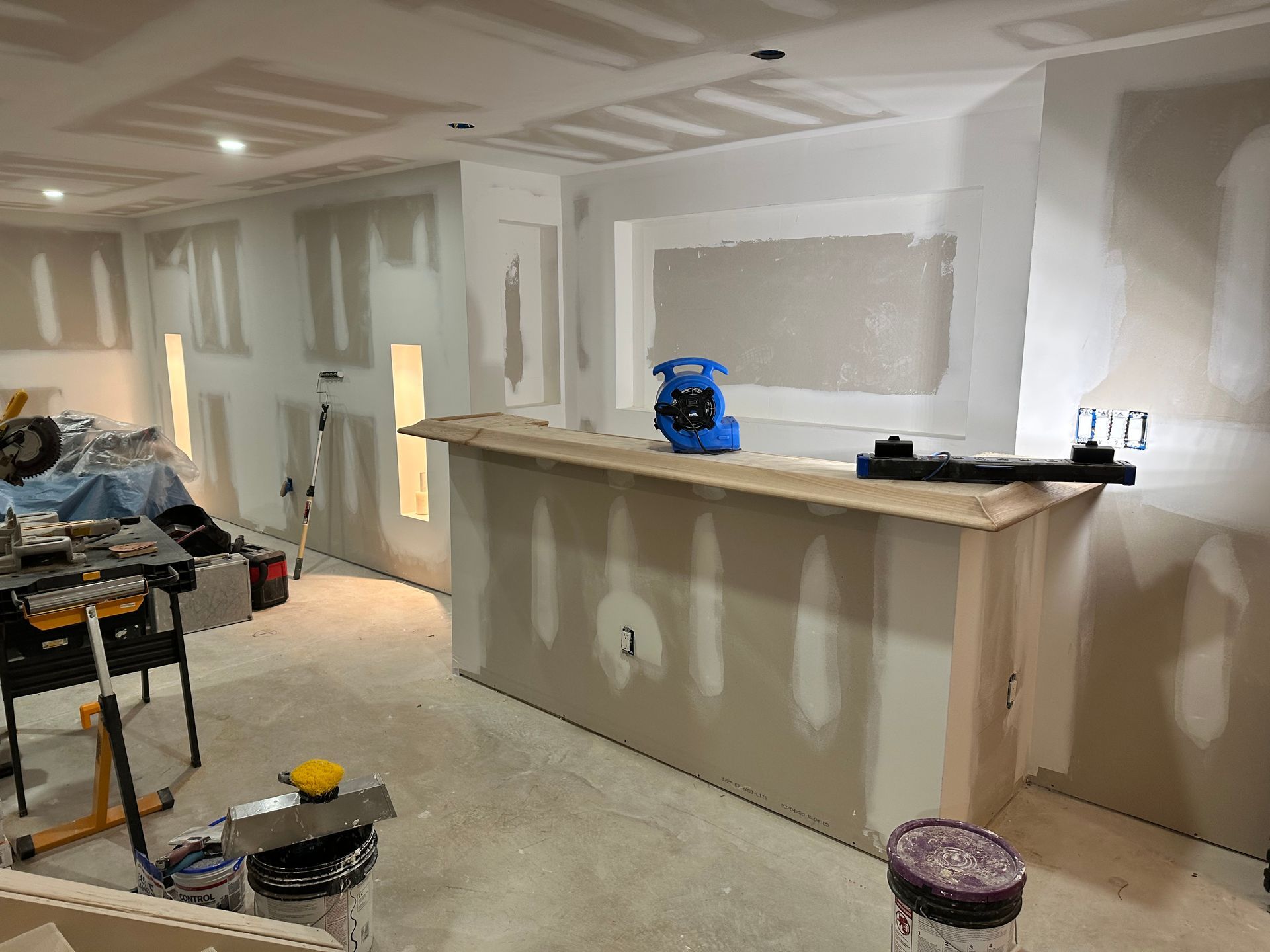 Counter and interior trim under construction with unfinished wall surfaces and tools