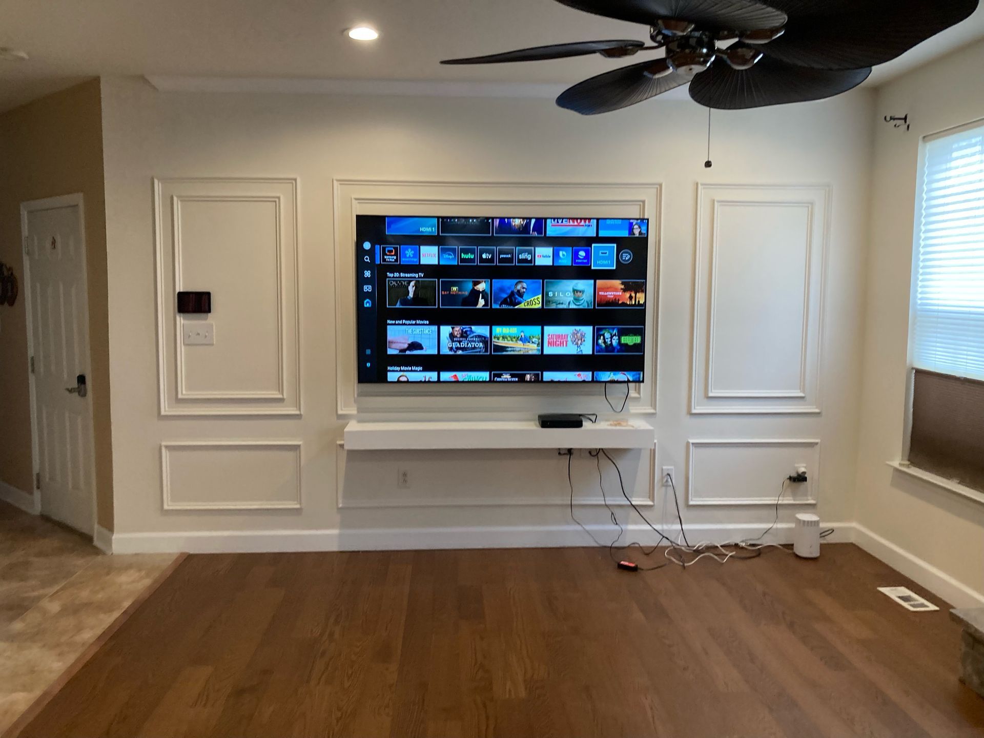 After: light living-room feature wall with decorative mouldings and a mounted television