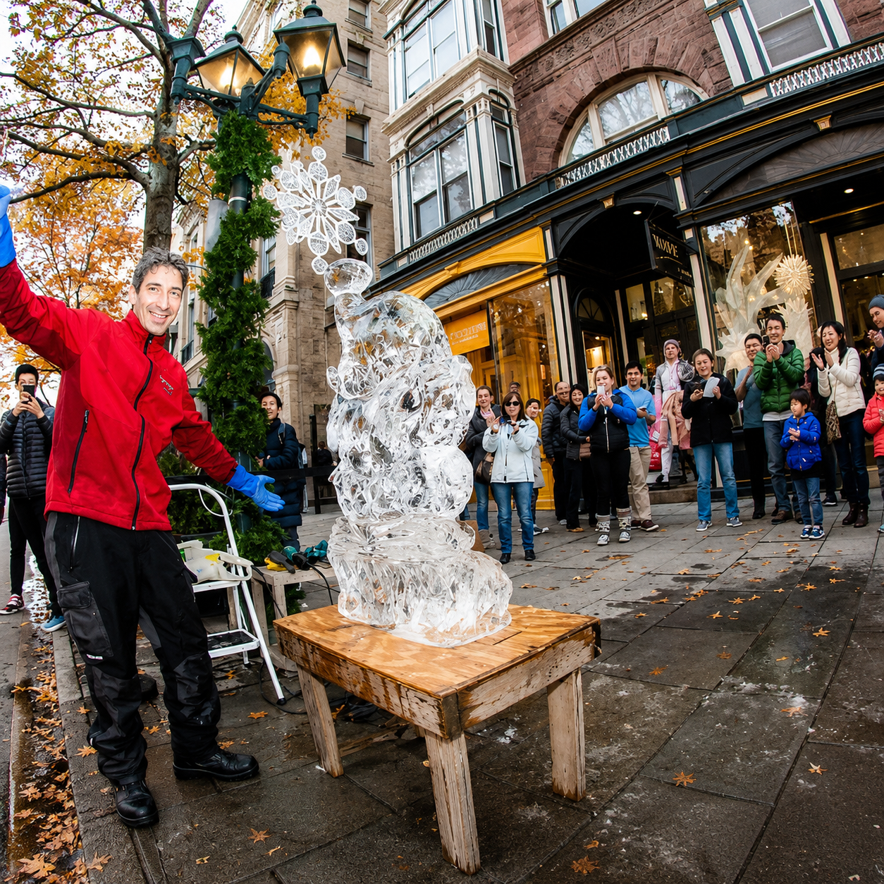 Person in red coat posing beside an ice sculpture on a wet city sidewalk during a street event