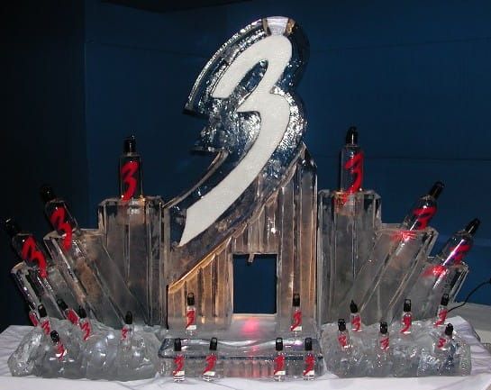 Silver “3” trophy centerpiece with red figures arranged around a stage-like display