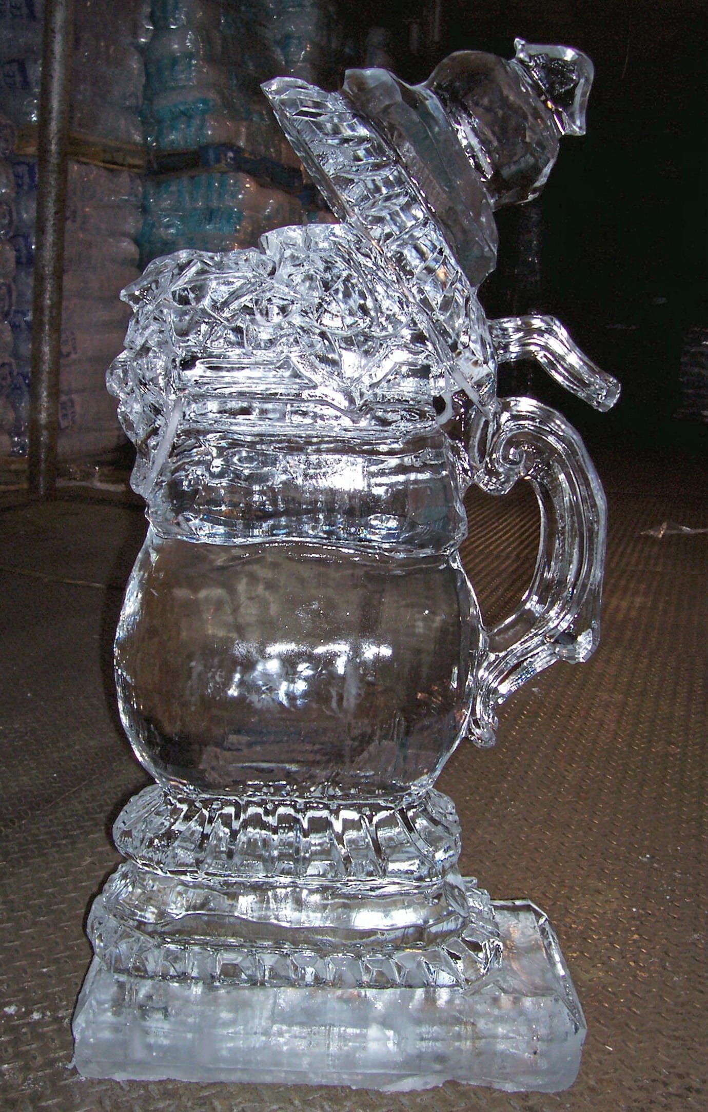 Clear glass mug covered in crinkled foil, shaped like a small sculpture on a table.