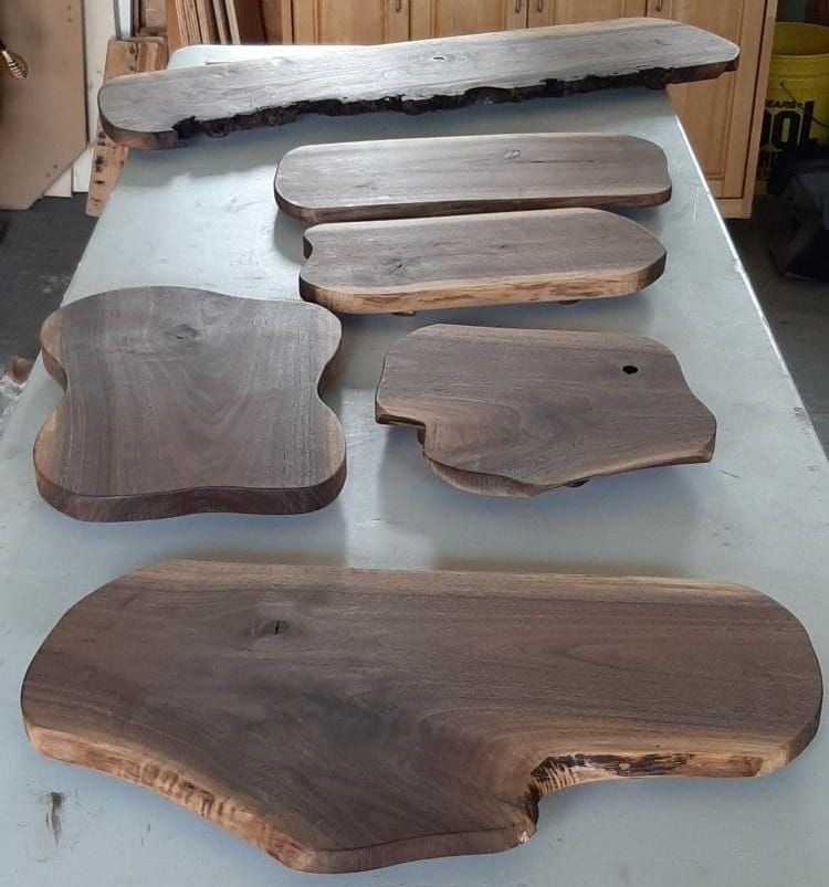 Wooden slabs with natural live edges arranged on a worktable in a workshop