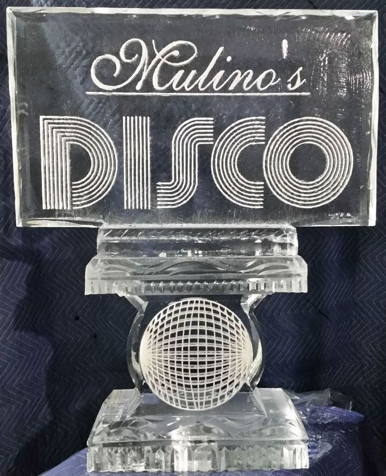 Clear glass trophy engraved “Molino’s Disco” with a microphone design on a dark background