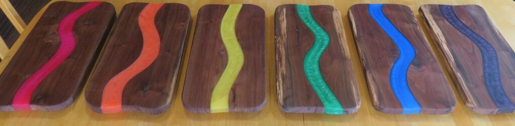 Six colorful wooden slingshot-shaped objects arranged in a row on a table