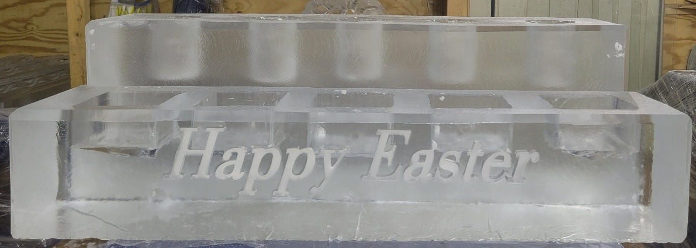 Clear glass block engraved “Happy Easter” on a shelf
