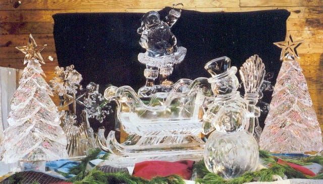 Crystal holiday display with a sleigh, snowman, trees, and stars on a dark background