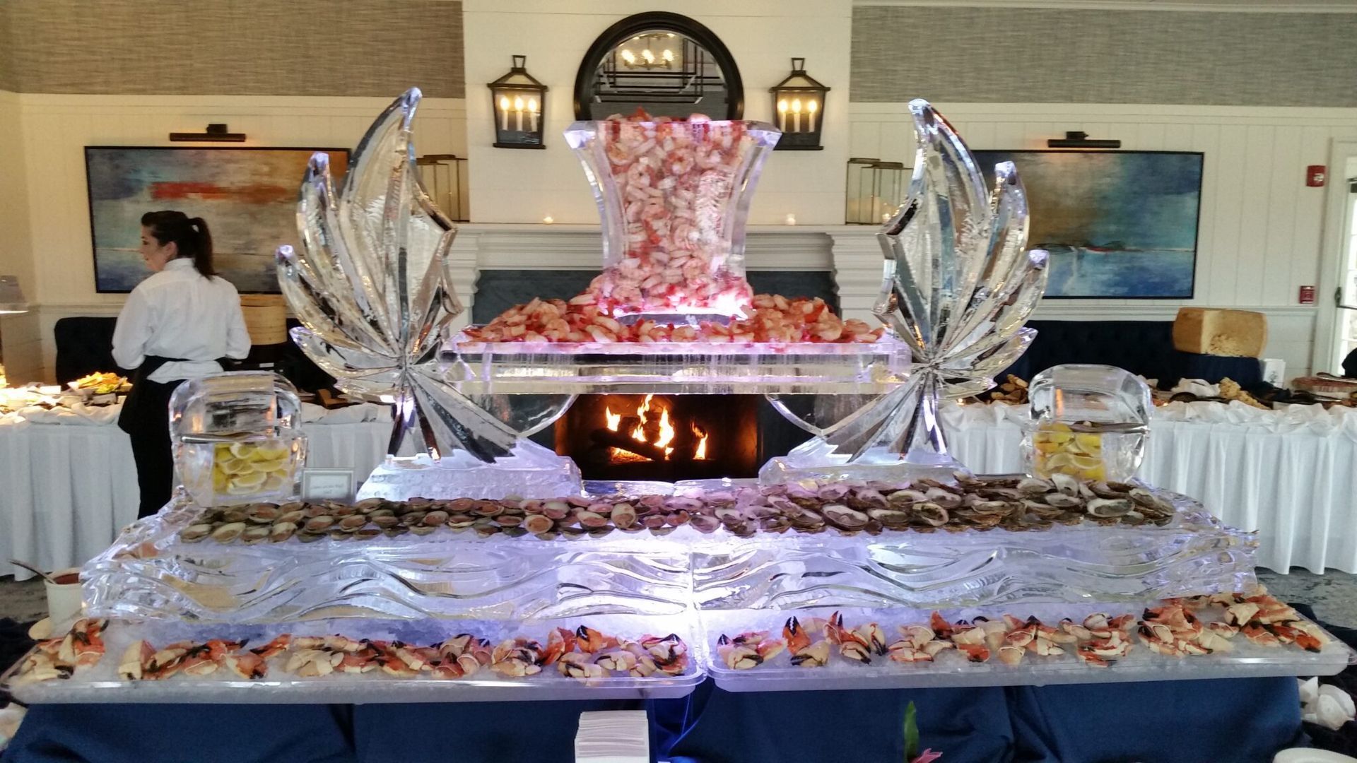 Elegant buffet display with silver decor and a pink-lit centerpiece in a banquet hall