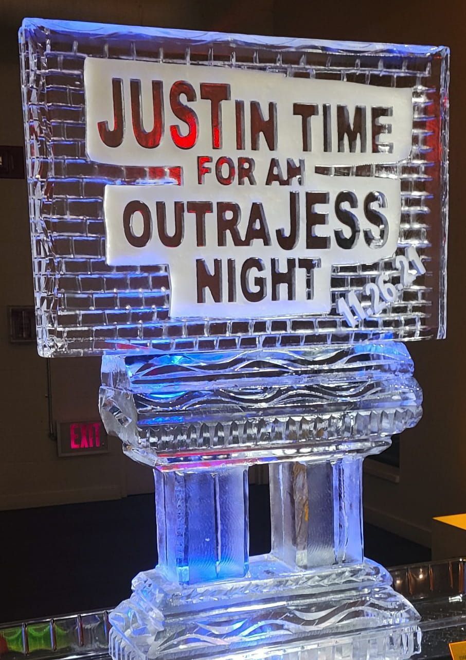 Ice sculpture with a sign reading “Just in time for an outrageous night” glowing blue.