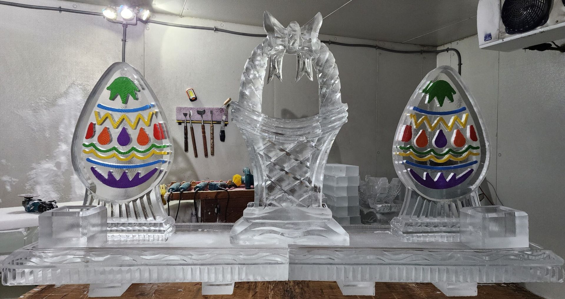 Decorative ice sculptures on a table, flanked by two colorful patterned egg displays.