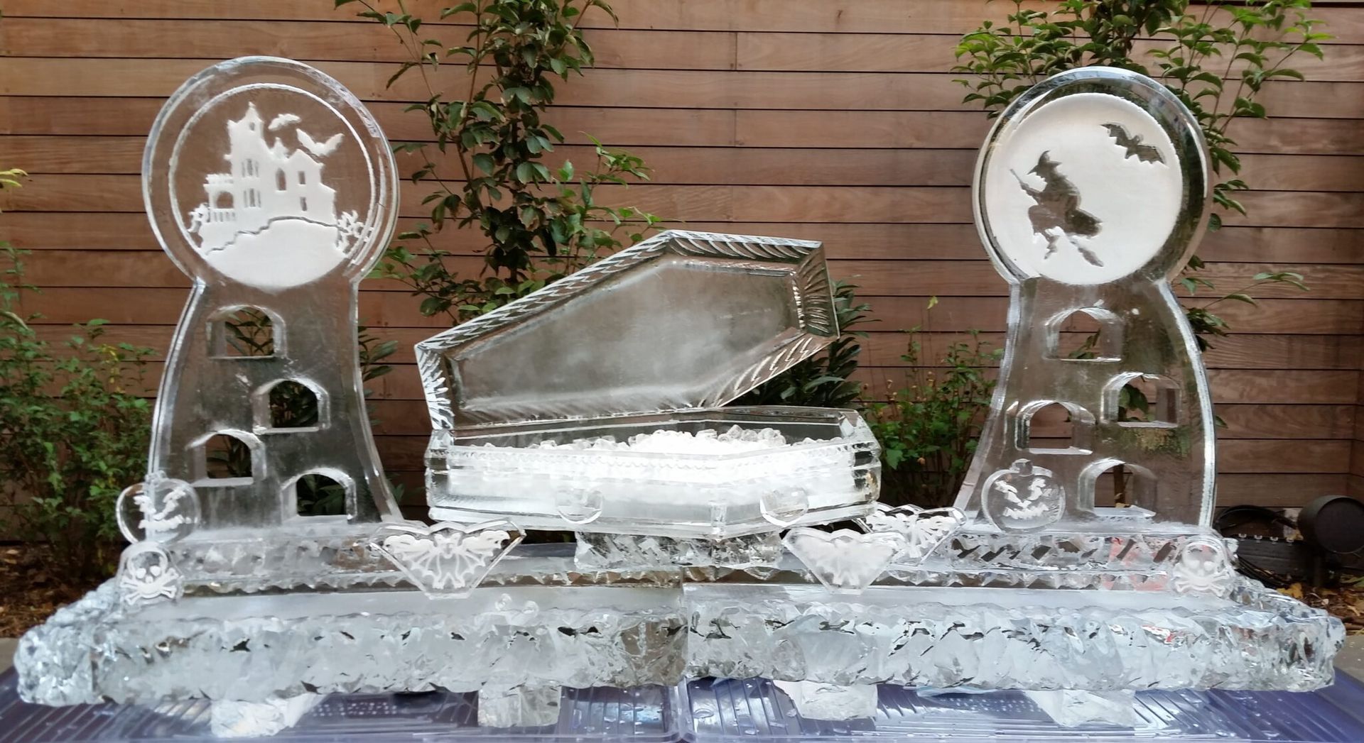 Ice sculpture with a central tray and two circular decorative panels on a wooden backdrop
