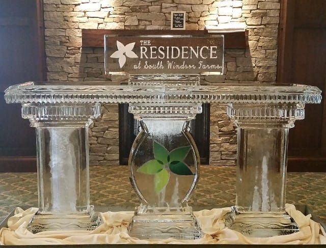 Decorative glass table with a “Residence” sign in a stone-walled lobby