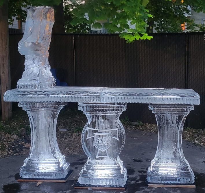Clear plastic furniture set with a table and three stools outdoors by a fence.