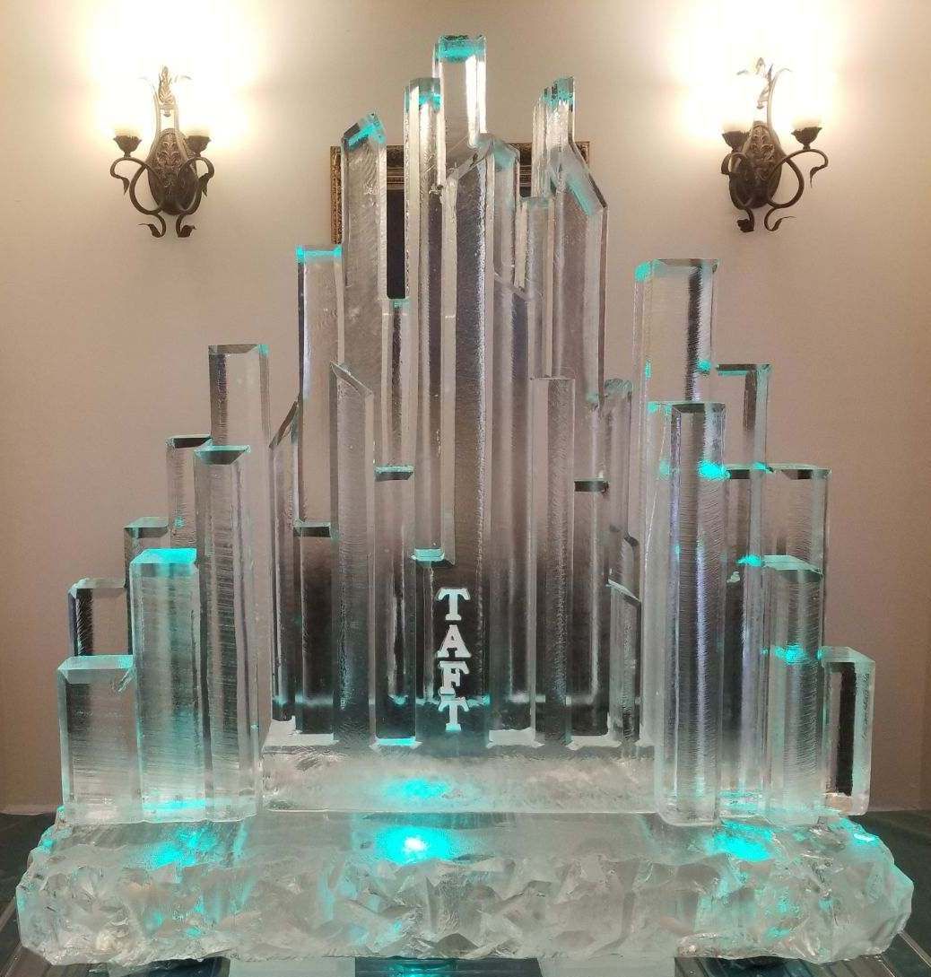 Crystal trophy display with turquoise lighting and tall glass towers on a mirrored base