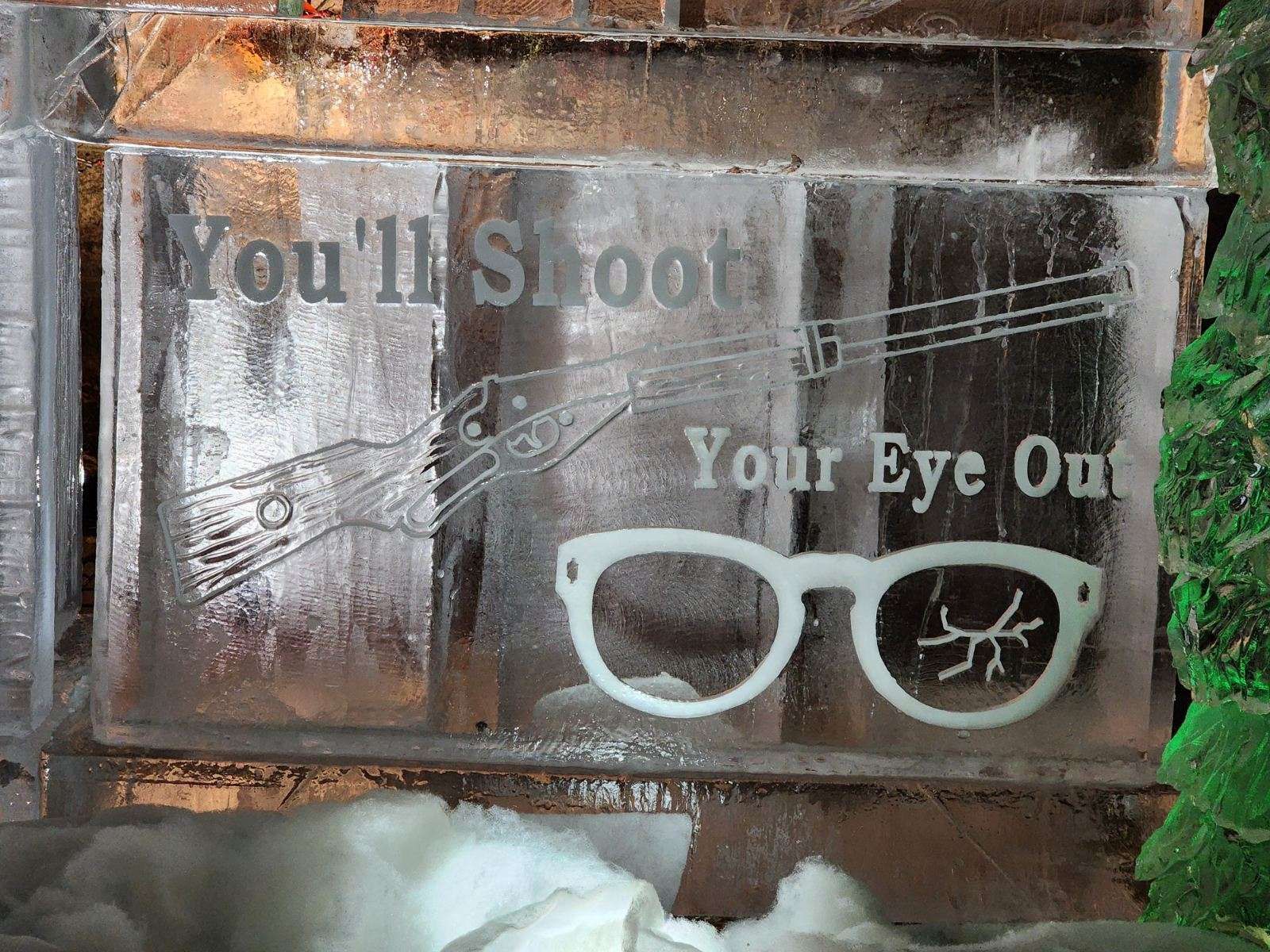 Graffiti reading “You’ll Shoot Your Eye Out” with white eyeglasses on a brick wall