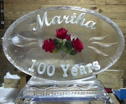 Clear engraved plaque with red roses and the name “Martha” above “100 years”