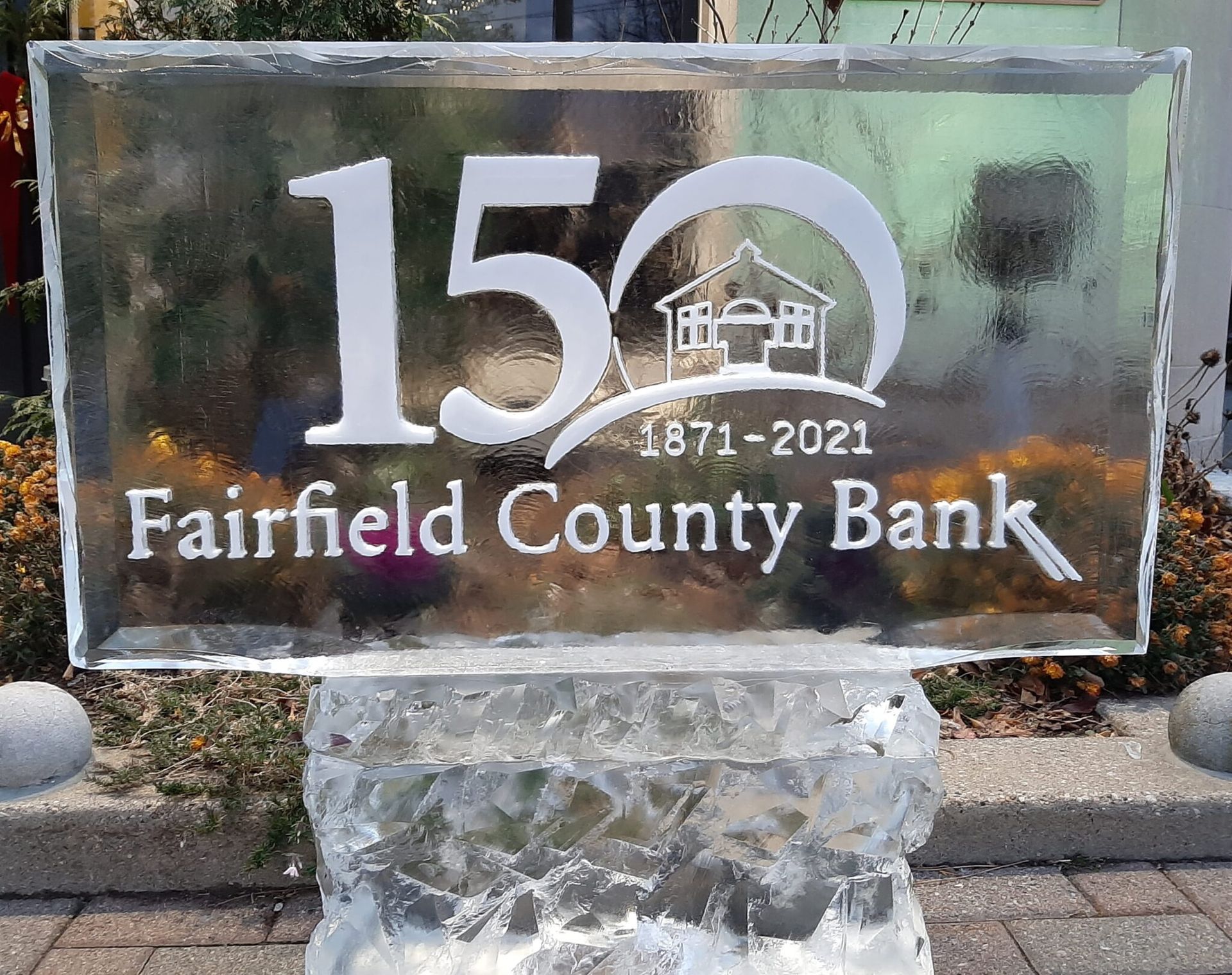 Glass sign for Fairfield County Bank with “150” and “1871–2021” etched on it.