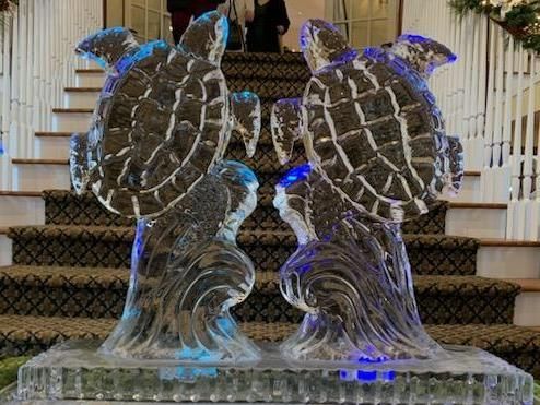 Ice sculpture of two owls on a staircase, lit with blue lights
