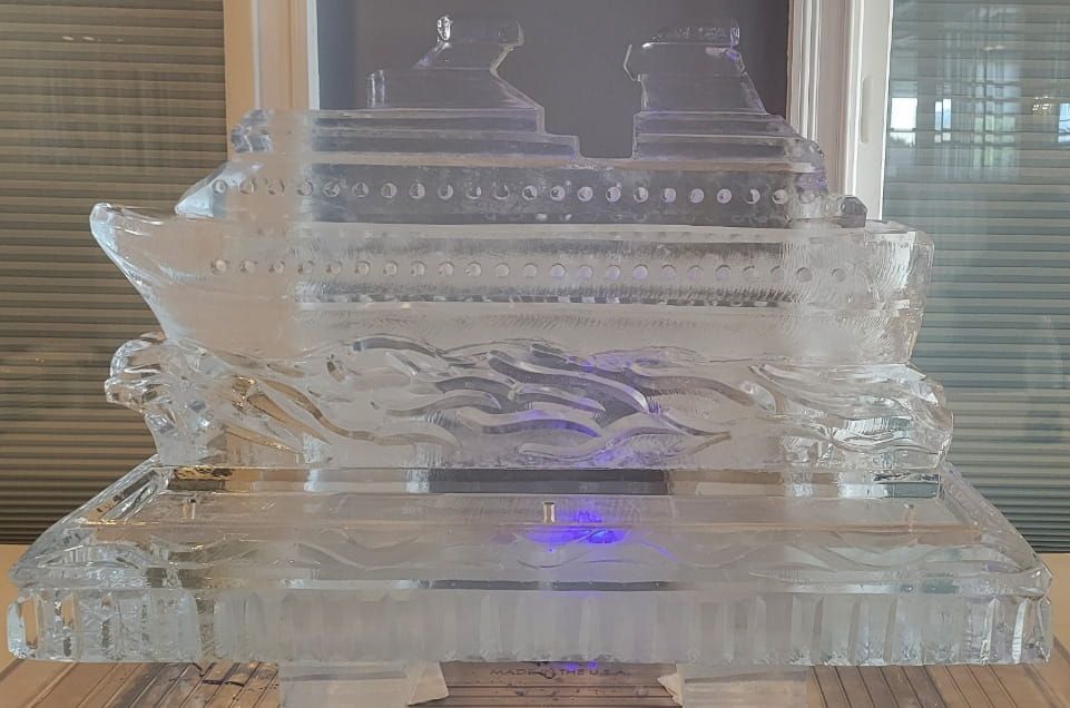 Clear glass decorative structure with layered tiers and a faint purple glow indoors