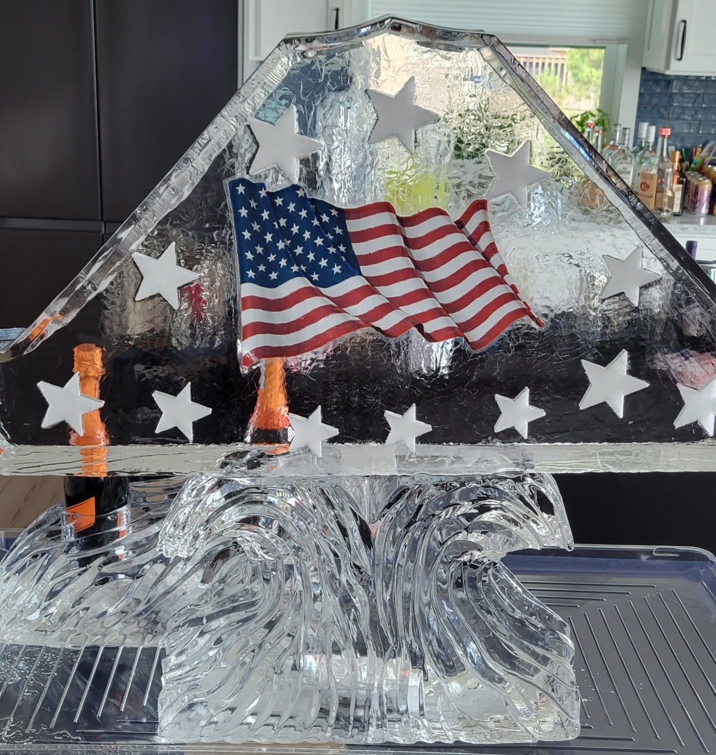 Clear decorative star sculpture with a small waving U.S. flag on a kitchen counter