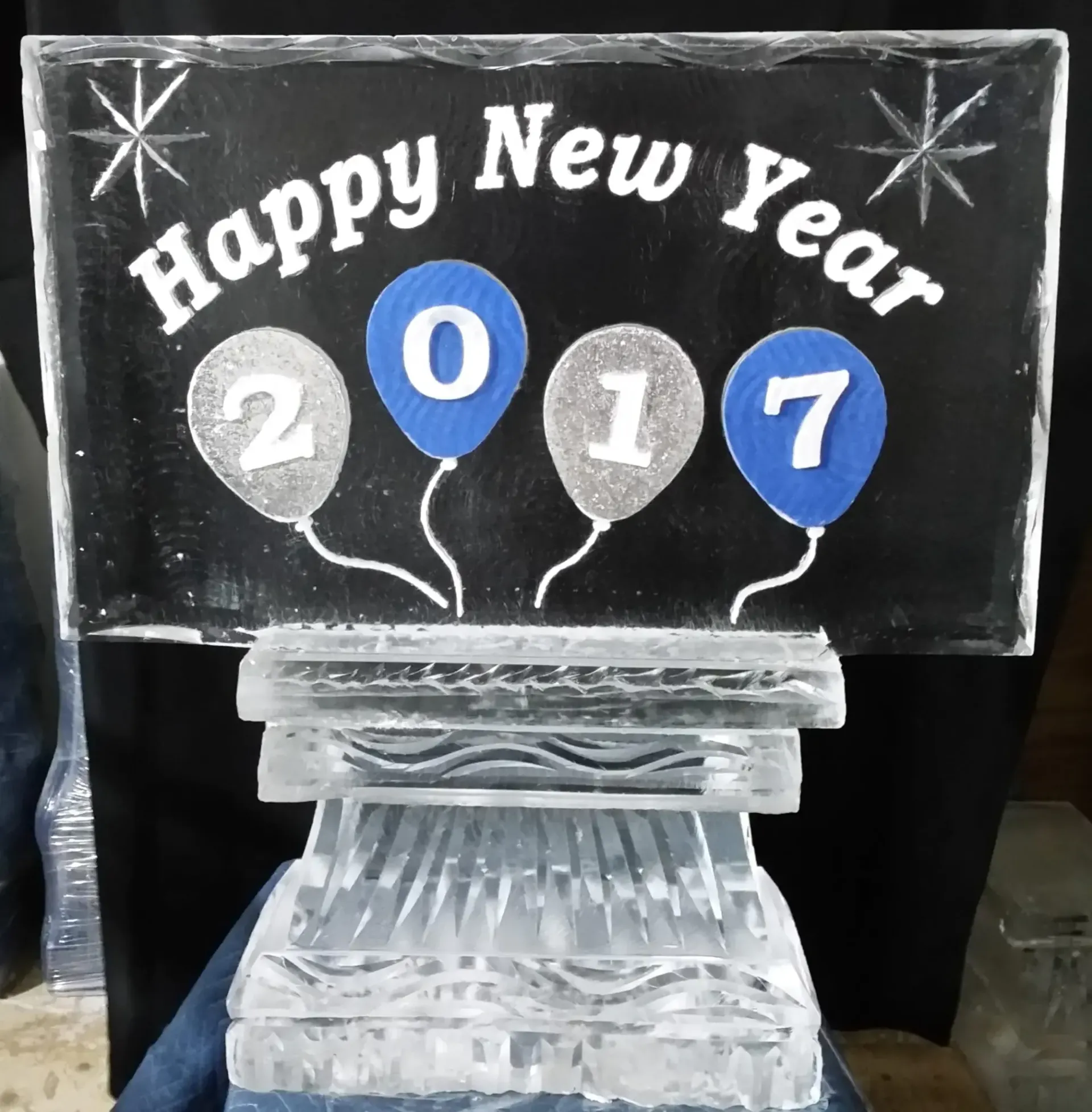 “Happy New Year” balloon sign with 2017 on a clear stand, decorated with stars