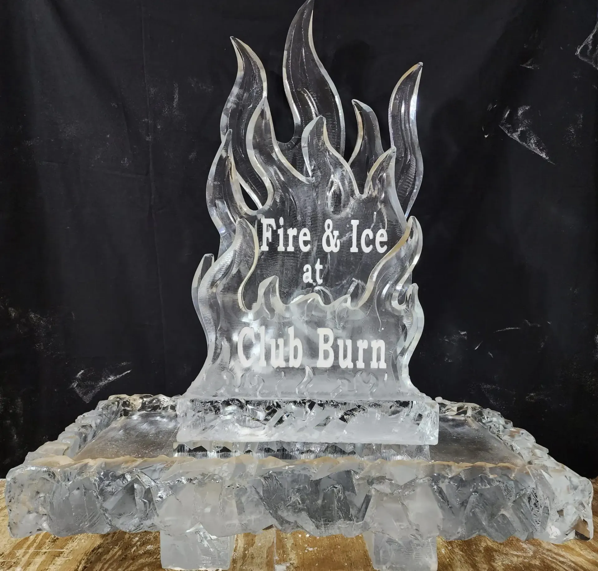Ice sculpture with flames and the text “Fire & Ice at Club Burn” on a dark background