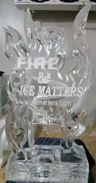 Clear ice sculpture trophy with text “FIRE & ICE MATTERS” on a table