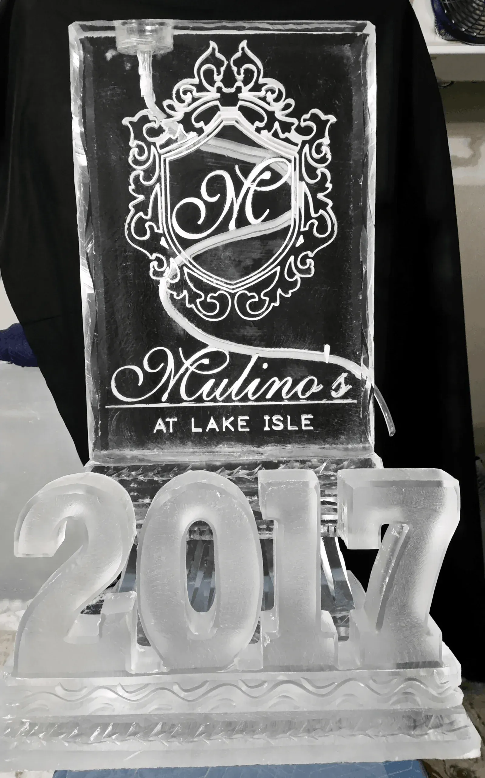 Clear crystal award with “2014” and “Mellina at Lake Isle” engraved on a black background.