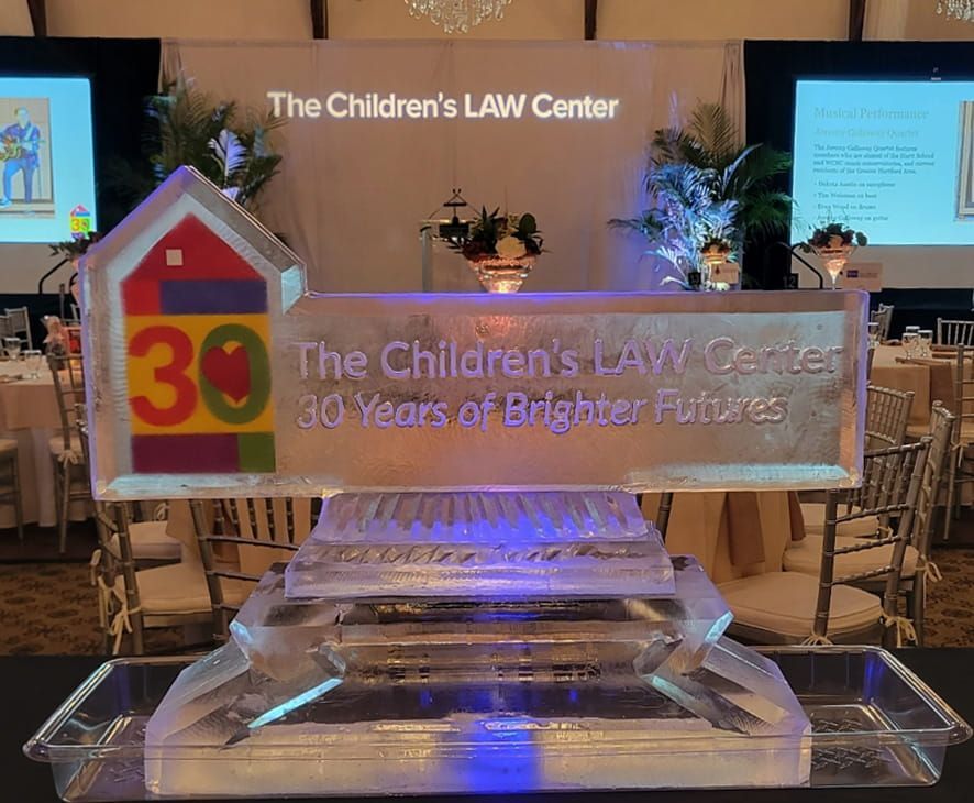 Transparent plaque for The Children’s Law Center’s 30 years of brighter futures on a lit stage.