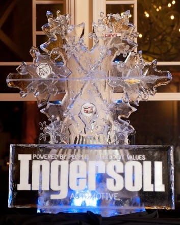 Clear glass award shaped like a snowflake with the Ingersoll logo lit in blue on a stand