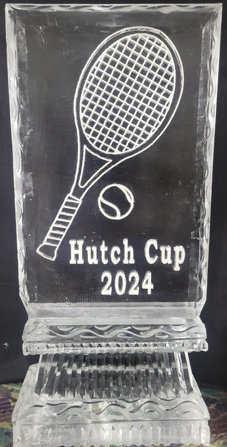 Clear glass trophy engraved with a tennis racket, ball, and the words “Hutch Cup 2024”