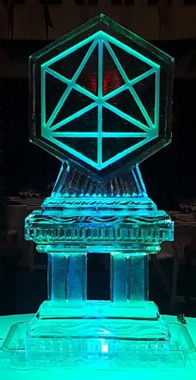 Glowing cyan geometric trophy on a pedestal, with a red triangle detail in the center