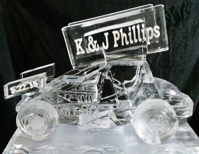 Clear acrylic race car trophy engraved “K&J Phillips” on a dark background