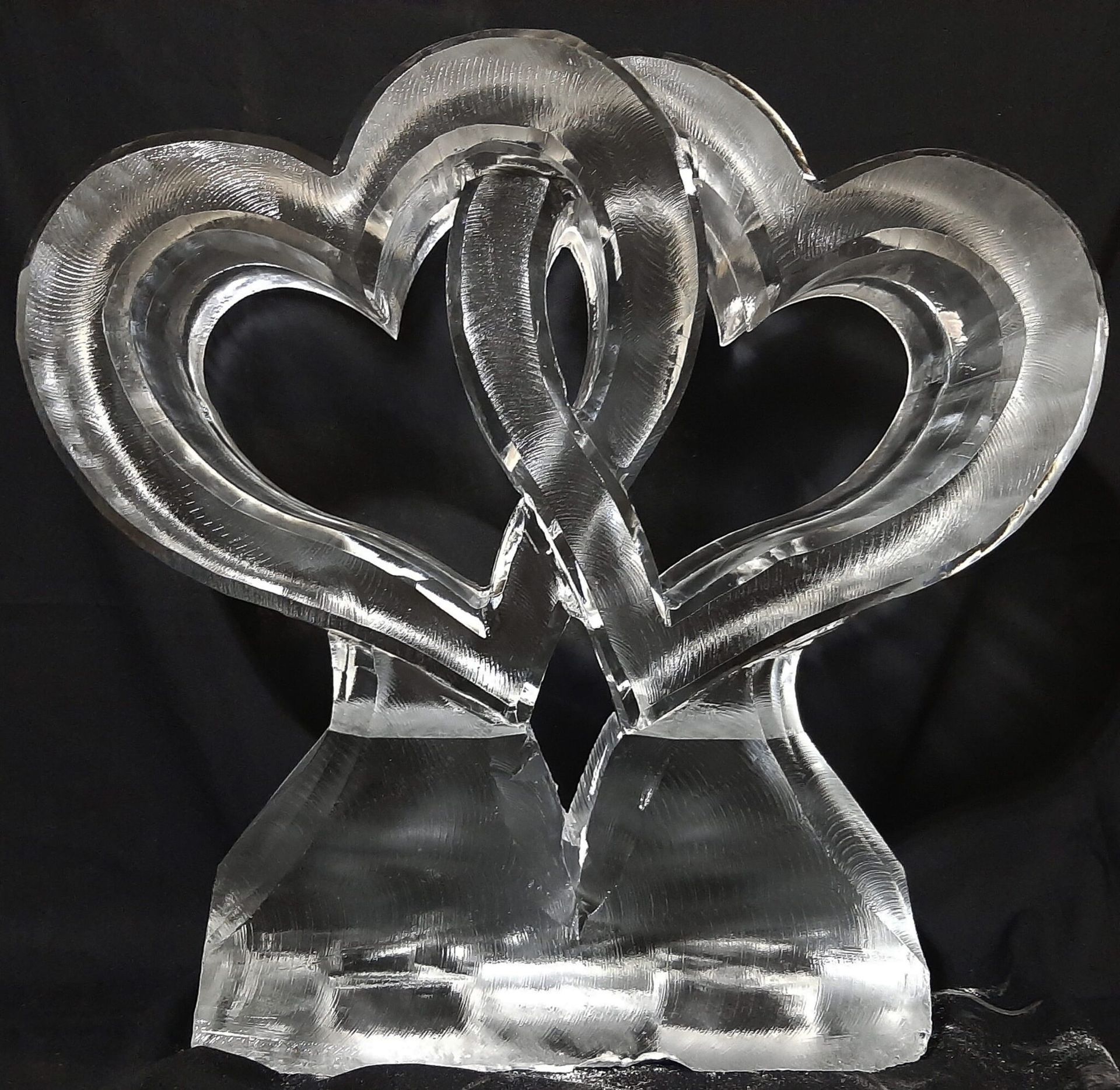 Clear glass heart-shaped sculpture on a black background