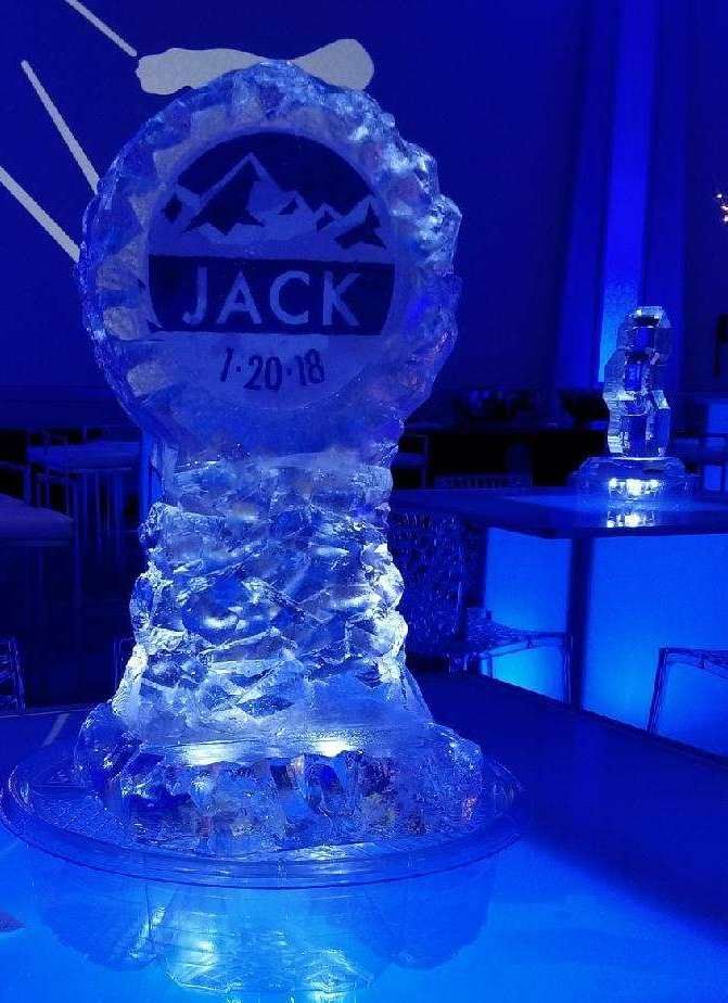 Ice sculpture sign reading “JACK” on a blue-lit table at an event