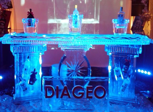 Blue-lit DIAGEO ice sculpture bar with bottles on top and a wheel design in the center
