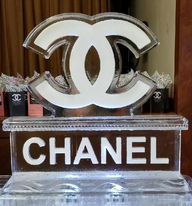 Chanel logo display in white on a clear base, with black CHANEL lettering below