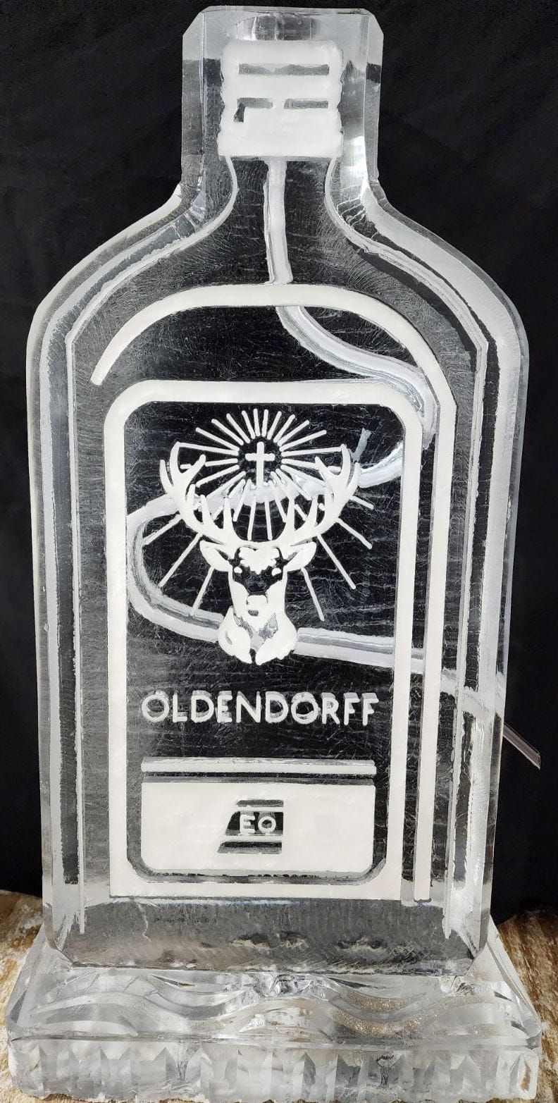 Clear glass bottle with a black-and-white Oldendorff label on a dark background
