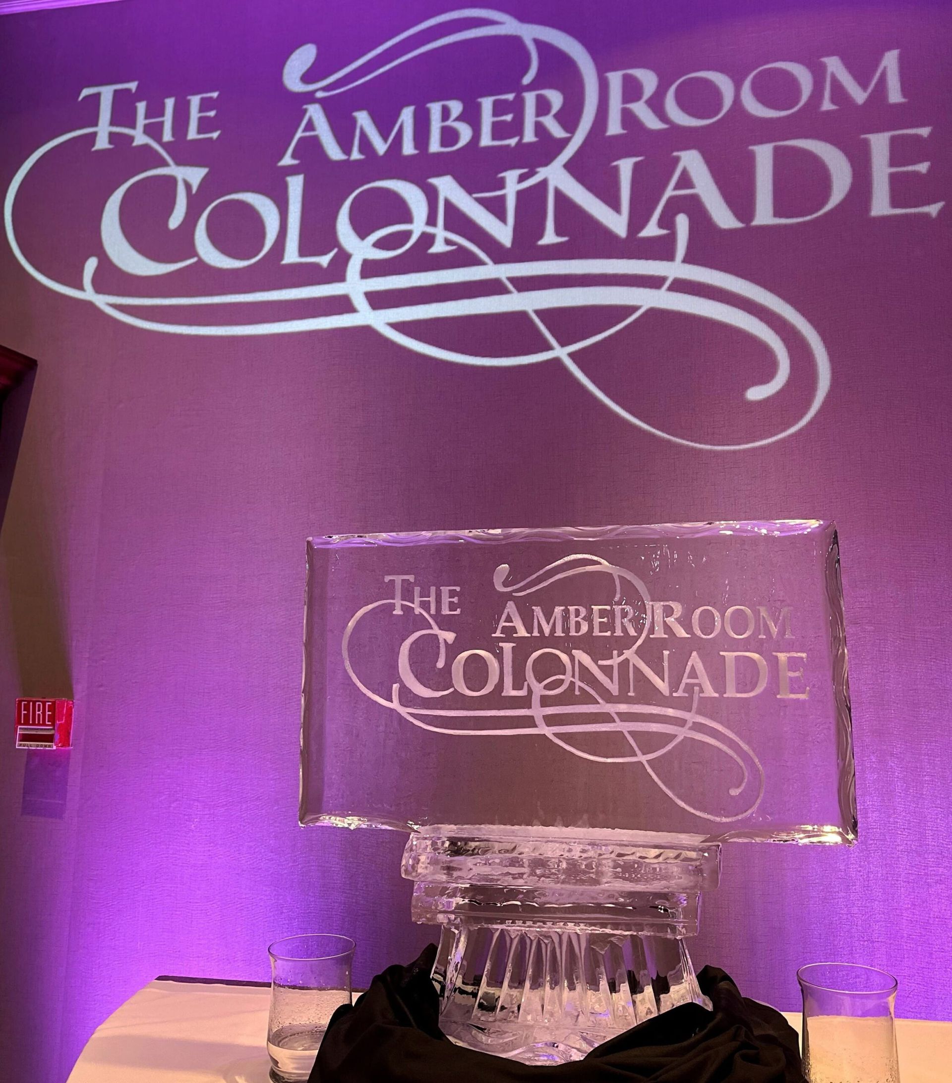 Amber room Colonnade sign on a purple-lit wall above a decorative ice sculpture