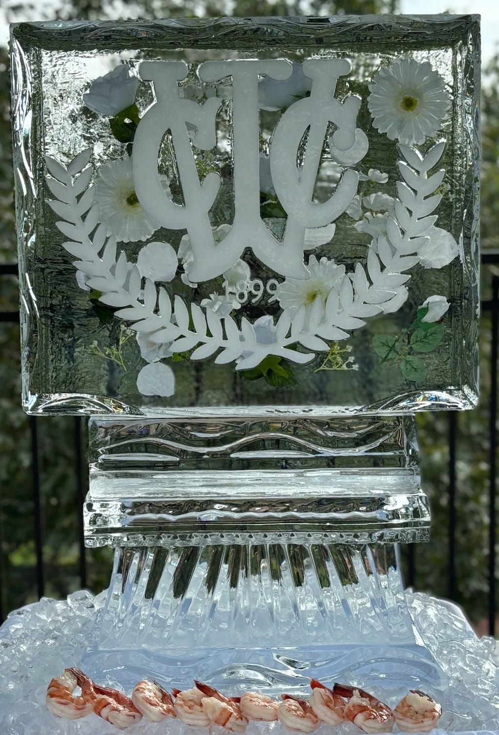 Frosted glass plaque on a stand, with decorative floral engraving and a line of orange petals at the base
