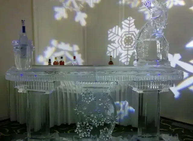 Decorated frosted glass mantel with snowflake light projections and small ornaments on top