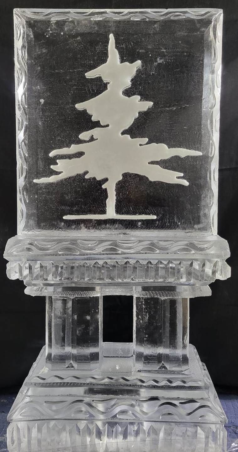 Clear glass award with a pine tree silhouette on a decorative transparent base.