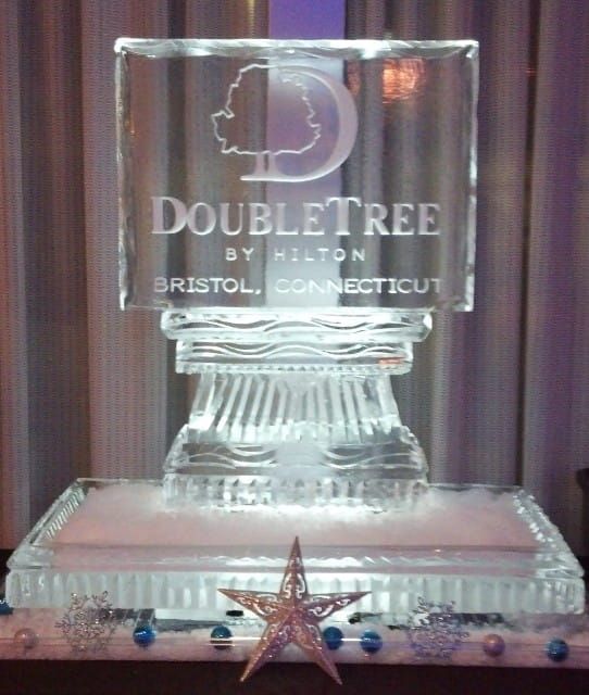 Clear glass award engraved “DoubleTree by Hilton Bristol, Connecticut” on a beaded stand with a starfish accent.