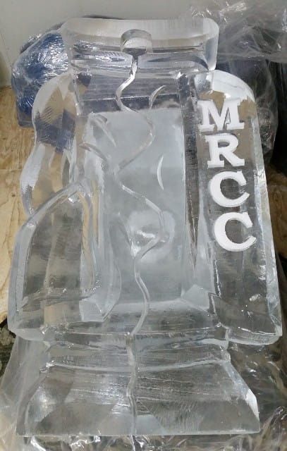 Clear glass trophy with a pedestal base and vertical “MPCC” letters on the side