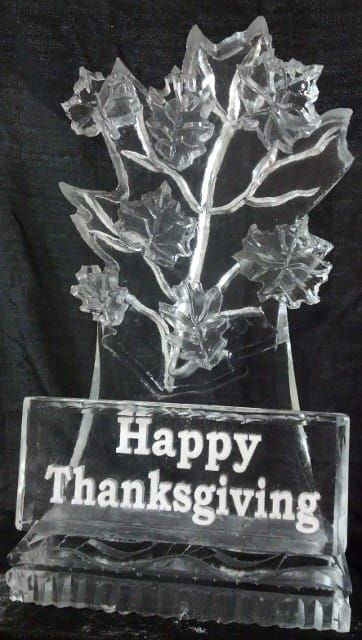 Clear glass Thanksgiving tabletop sculpture with flowers and “Happy Thanksgiving” text.