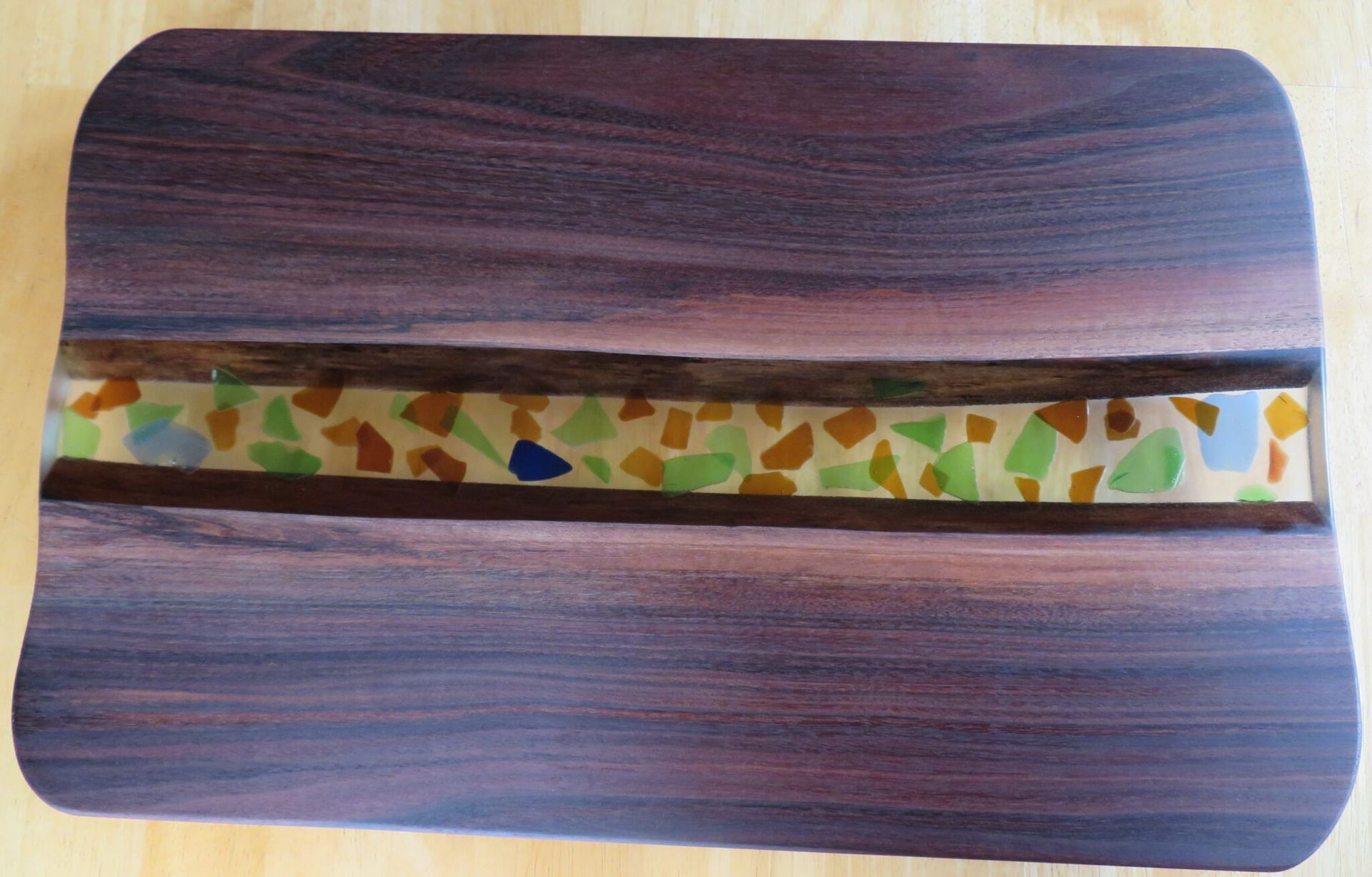 Wood-grain tray with a narrow central strip of multicolored geometric pattern